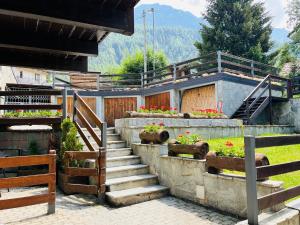 a set of stairs leading to a building with flowers at GuestHost - Mulino del Bianco - Comfy Studio-Flat in La Thuile