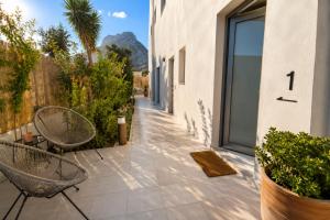 a patio with two chairs and a building at MIRA MARE - Apartments 1 & 8 in Stavros
