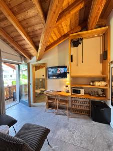 a living room with a table and a tv at B&B Casa il sasso in Pinzolo