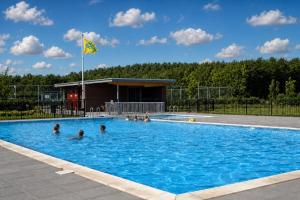 a group of people in a swimming pool at Villa Vera - Comfort, Space, Sauna & Hot Tub in Private Garden in Zeewolde