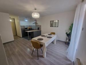 ein Wohnzimmer mit einem weißen Tisch und Stühlen in der Unterkunft Zéline in Montholon