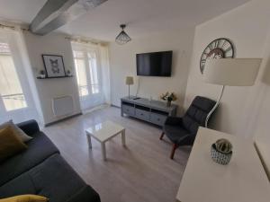 ein Wohnzimmer mit Sofa und Tisch in der Unterkunft Zéline in Montholon