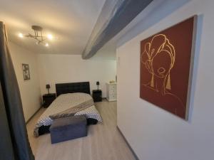 ein Schlafzimmer mit einem Bett und einem Gemälde an der Wand in der Unterkunft Zéline in Montholon