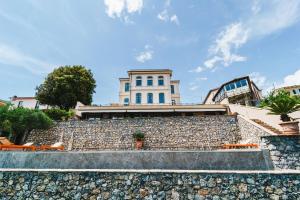 a building on top of a stone wall at Miramare Apartments&Suites in La Spezia