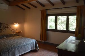 a bedroom with a bed and a window at La Felce e il Mirtillo in Il Palazzo