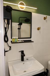 a bathroom with a sink and a mirror at The Fireplace ROOM in Borjomi +12 photos
