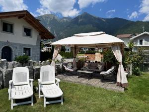 a patio with two chairs and an umbrella at B&B Casa il sasso in Pinzolo