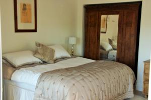 a bedroom with a bed and a mirror at Watchcombe House in Colyton