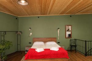 a bedroom with a bed with a red blanket at The Fireplace ROOM in Borjomi