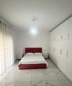 a bedroom with a red bed and white cabinets at Twobedrooms house in Polisi i Vogël