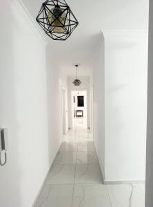 a hallway with white walls and a ceiling with a light fixture at Twobedrooms house in Polisi i Vogël