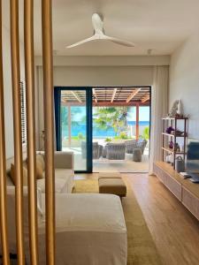 a living room with a couch and a ceiling fan at Breathtaking seaview penthouse - Belle Mare in Post of Flacq