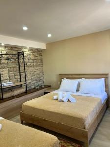 a bedroom with two beds with towels on them at Guest House Mene in Gjirokastër