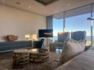 a living room with a bed and a couch and a tv at Horizon House in Mossel Bay