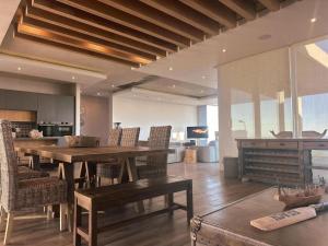a living room with a wooden table and chairs at Horizon House in Mossel Bay
