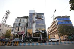 a tall building with cars parked in front of it at Ananya Comfortss in Hospet