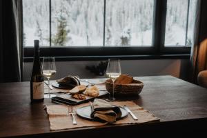 a table with a bottle of wine and bread and wine glasses at Mountain Hideway Birgkar in Mühlbach am Hochkönig