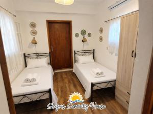 two beds in a room with white sheets at Skyros Serenity House in Skiros