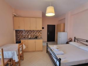a room with two beds and a table and a kitchen at Let Rooms Lukova in Lukovë