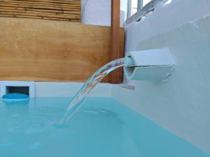 a stream of water pouring into a bath tub at B&B "Pulia Dimore Salentine" in Alessano