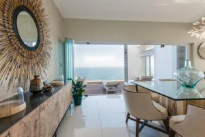 a dining room with a table and a mirror at White Water Retreat - Pinnacle Point in Mossel Bay