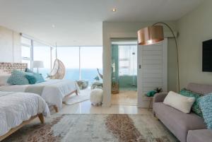a bedroom with two beds and a couch at White Water Retreat - Pinnacle Point in Mossel Bay