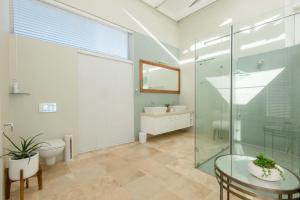 a bathroom with a glass shower and a toilet and a sink at White Water Retreat - Pinnacle Point in Mossel Bay +67 photos