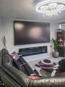 a living room with a leather couch and a large flat screen tv at The River Condos in Detroit