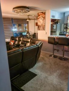 a living room with a leather couch and a bar at The River Condos in Detroit