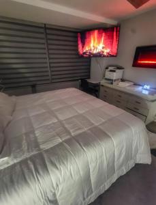 a bedroom with a large bed and a desk with a fire in it at The River Condos in Detroit +15 photos