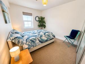 a bedroom with a bed and a chair in it at Dog friendly sea front apartment with balcony in Pendine
