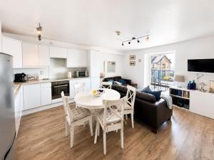 a kitchen and a living room with a table and chairs at Dog friendly sea front apartment with balcony in Pendine +11 photos