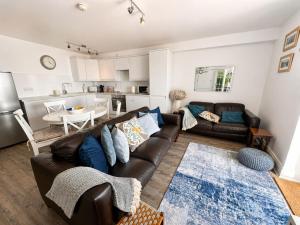 a living room with a couch and a table at Dog friendly sea front apartment with balcony in Pendine
