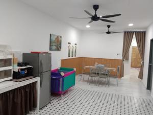 a kitchen and dining room with a ceiling fan at Kenari homestay in Gopeng