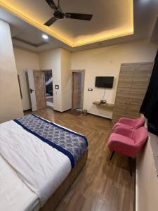 a bedroom with a bed and a flat screen tv at Hotel Keshav Villa in Mandhana