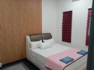 a bedroom with a bed with two pillows on it at Kenari homestay in Gopeng