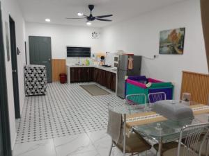 a kitchen with a table and a ceiling fan at Kenari homestay in Gopeng