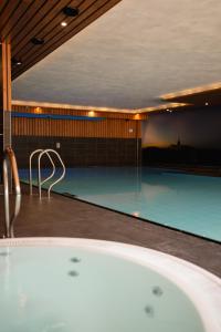 a bath tub in a room with a swimming pool at ´t Wapen van Marion in Oostvoorne