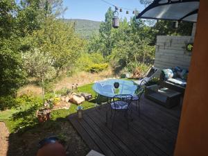 a patio with a table and chairs on a deck at Nature stopover in green Provence in Artigues