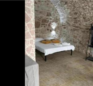 a bedroom with a bed in a stone wall at Spina home in Vieste
