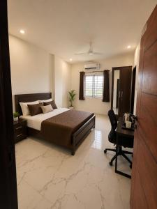 a bedroom with a bed and a desk and a chair at Mahankali Guest House in Hyderabad