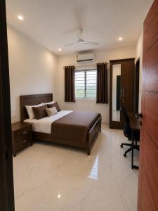a bedroom with a bed and a desk and a computer at Mahankali Guest House in Hyderabad