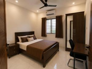 a bedroom with a bed and a desk in it at Mahankali Guest House in Hyderabad