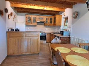 a kitchen with wooden cabinets and a table with chairs at Diófa Vendégházak in Tiszafüred