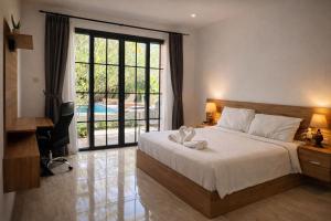 a bedroom with a bed and a large window at AA Guest House Padonan in Dalung