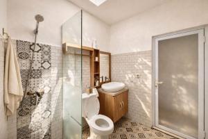 a bathroom with a toilet and a shower at AA Guest House Padonan in Dalung