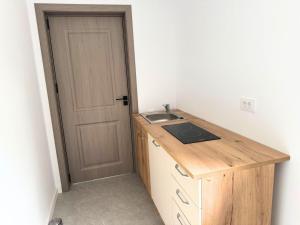 a small kitchen with a sink and a door at Păușa Residence in Păuşa