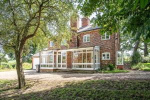 an old brick house with a large glassconservatory at Drift Cottage, Rendlesham in Rendlesham