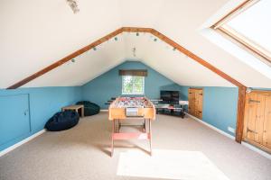 a room with a table in the middle of a attic at Drift Cottage, Rendlesham in Rendlesham