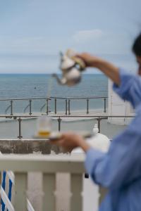 a man holding a bird on a balcony with the ocean at Riad Mazal Mogador in Essaouira +121 photos